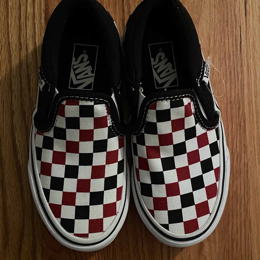 Black, white, and red checkered VANS shoes
